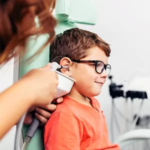 an audiologist is flushing the ears of a young boy