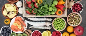 big spread of heart-healthy foods such as fish, nuts, fruit, vegetables, garlic