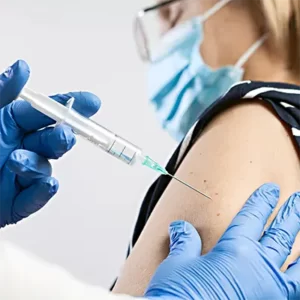 closeup of syringe about to enter left arm on female patient